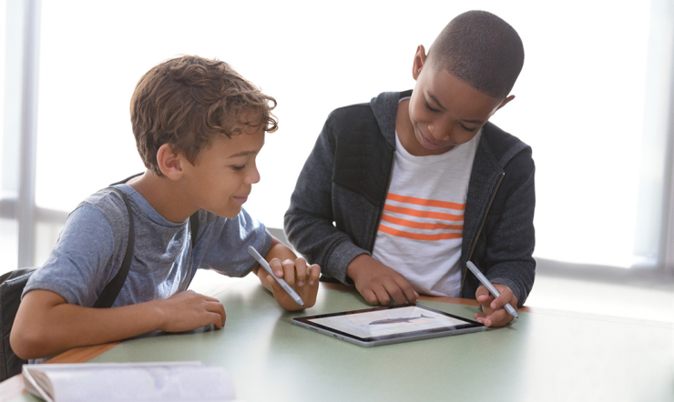 2 kids playing on a Surface Go