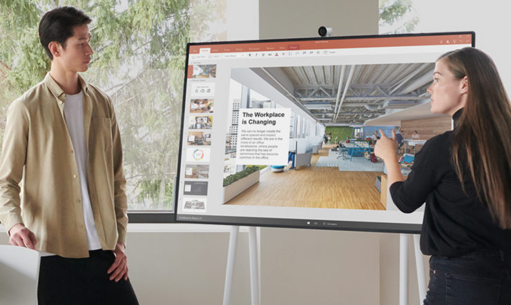 a man and a woman standing in front of a computer