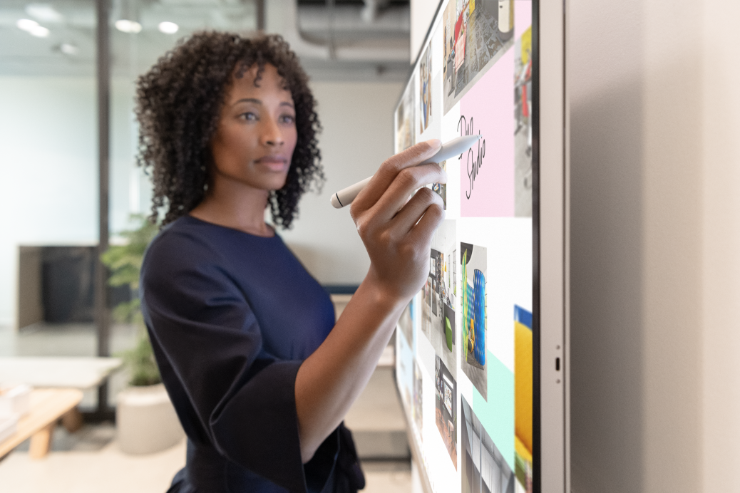Woman executive working on Surface Hub 2S in Whiteboard with Surface Hub 2 Pen