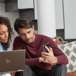 una persona seduta a un tavolo che utilizza un computer portatile