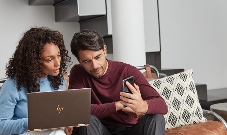 en person sidder ved et bord og bruger en laptop