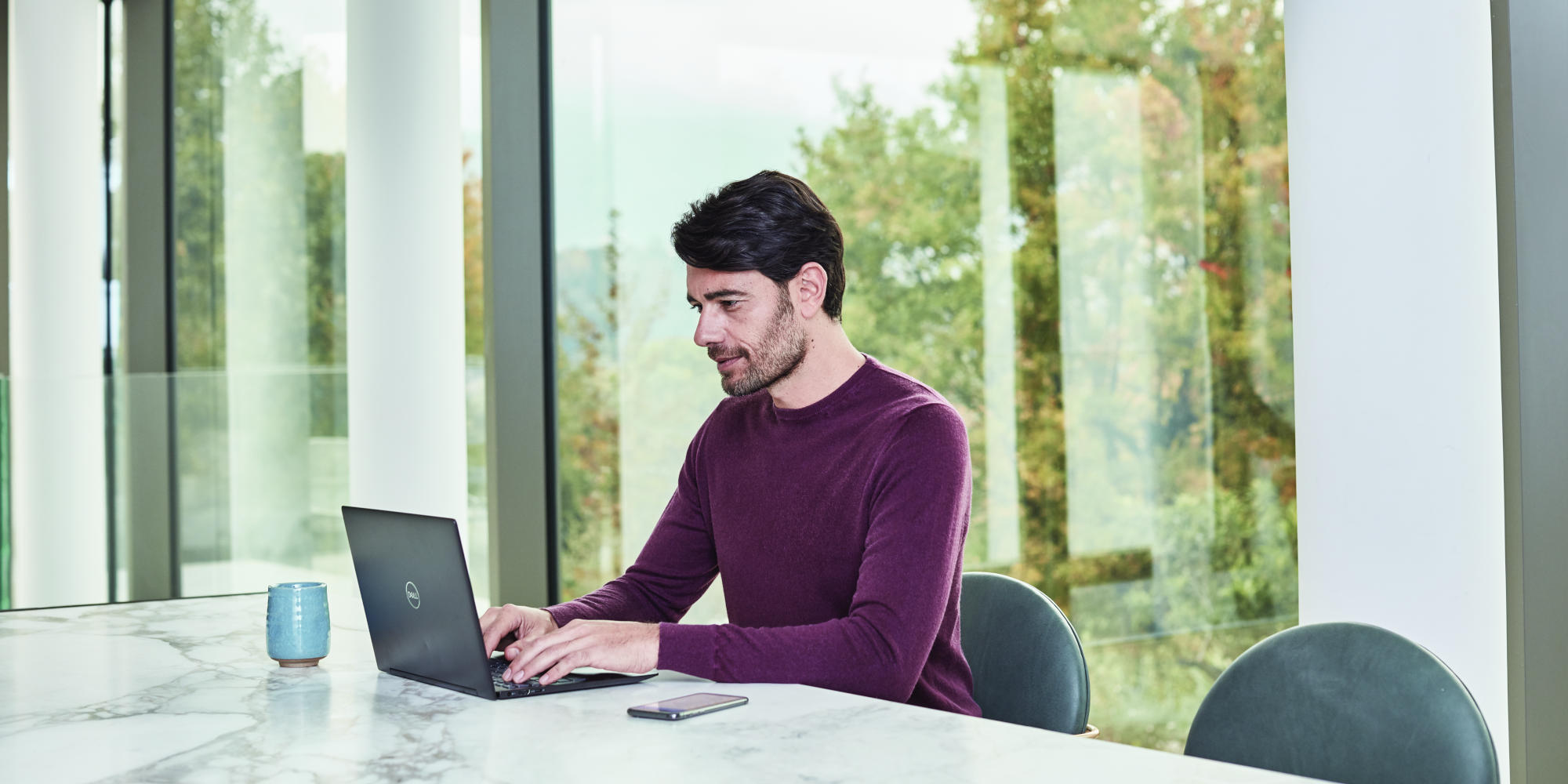 a person sitting at a table using a laptop computer