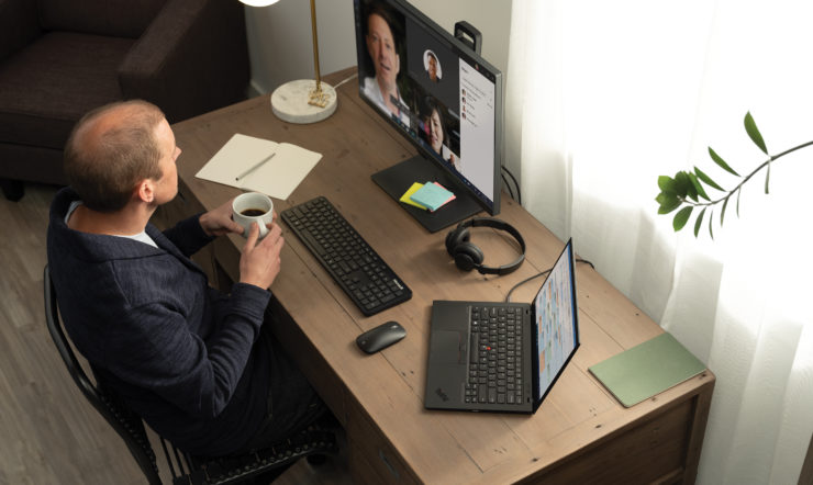 a man sitting at a desk with a computer on a table